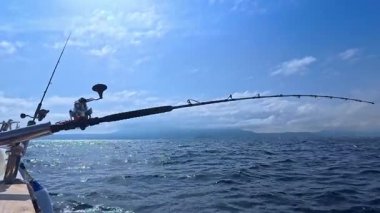 Balıkçı oltası ve balıkçı oltası okyanus denizinde tuna balığı avlamak için tekneden çekiliyor.
