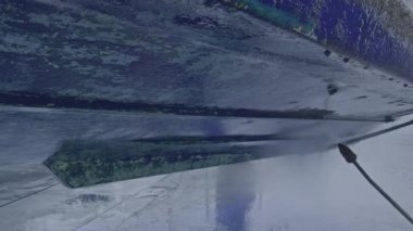 Kuru rıhtımda bakım sırasında tekne gövdesinden eski antiseptik boyayı söküp alan yüksek basınçlı su aleti.