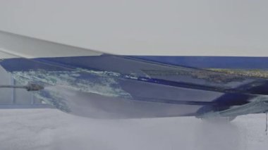 Kuru rıhtımda bakım sırasında tekne gövdesinden eski antiseptik boyayı söküp alan yüksek basınçlı su aleti.