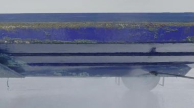 Kuru rıhtımda bakım sırasında tekne gövdesinden eski antiseptik boyayı söküp alan yüksek basınçlı su aleti.