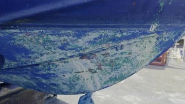 El kazıyıcı, eski anti-osmoz gövde tedavisine hazır hale getirmek için tekne gövdesinden eski antiseptik boyayı çıkarır.