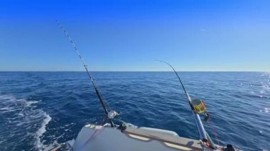 Balıkçı teknesi okyanus denizinde teknede olta ve makaralarla tuzlu su avlıyor.