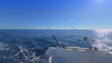 Balıkçı teknesi okyanus denizinde teknede olta ve makaralarla tuzlu su avlıyor.