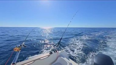 Balıkçı teknesi okyanus denizinde teknede olta ve makaralarla tuzlu su avlıyor.