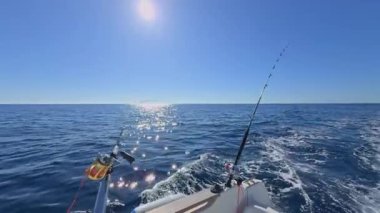 Balıkçı teknesi okyanus denizinde teknede olta ve makaralarla tuzlu su avlıyor.