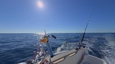 Balıkçı teknesi okyanus denizinde teknede olta ve makaralarla tuzlu su avlıyor.