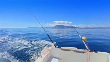 Balıkçı teknesi okyanus denizinde teknede olta ve makaralarla tuzlu su avlıyor.
