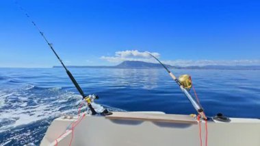 Balıkçı teknesi okyanus denizinde teknede olta ve makaralarla tuzlu su avlıyor.