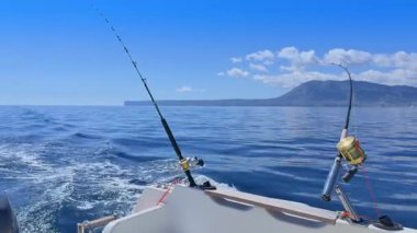 Balıkçı teknesi okyanus denizinde teknede olta ve makaralarla tuzlu su avlıyor.