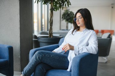 Cafe 'de internetten bilgisayar ve kulaklık kullanan neşeli bir kız öğrenci..