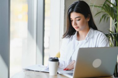 Cafe 'de internetten bilgisayar ve kulaklık kullanan neşeli bir kız öğrenci..
