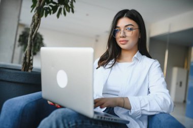 Gülümseyen kız öğrenci çalışması Skype öğretmeniyle, mutlu genç kadın dil öğreniyor. Ders dinliyor. Webinar yazıları yazıyor..