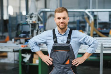 Alüminyum, PVC pencere ve kapı üretim fabrikası. PVC pencere ve kapılarını birleştiren el işçisi