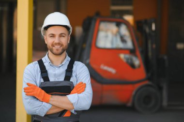 Depoda çalışan ve forklift kullanan bir adam..