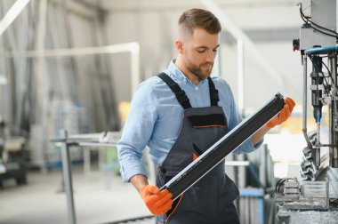 Alüminyum, PVC pencere ve kapı üretim fabrikası. PVC pencere ve kapılarını birleştiren el işçisi.