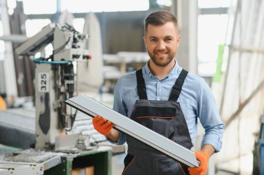 Alüminyum, PVC pencere ve kapı üretim fabrikası. PVC pencere ve kapılarını birleştiren el işçisi.