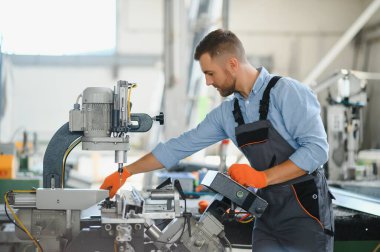 Alüminyum, PVC pencere ve kapı üretim fabrikası. PVC pencere ve kapılarını birleştiren el işçisi.