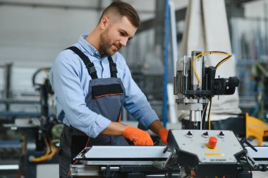Alüminyum, PVC pencere ve kapı üretim fabrikası. PVC pencere ve kapılarını birleştiren el işçisi.