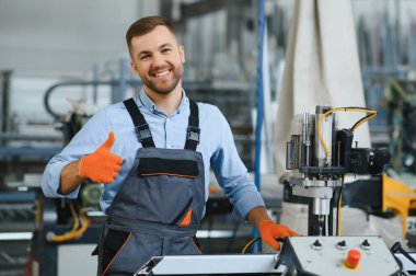 Alüminyum, PVC pencere ve kapı üretim fabrikası. PVC pencere ve kapılarını birleştiren el işçisi.