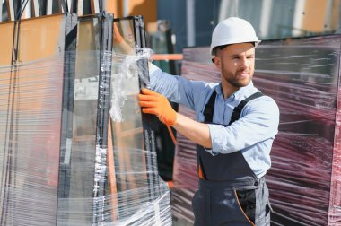 İşçiler cam aktarın. Fabrikada üretim Windows ve alüminyum ve Pvc kapılar için.