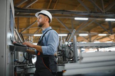 Fabrika işçisi. Üretim hattında çalışan adam.