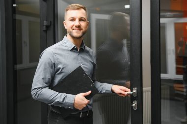 Dükkanda anahtarı olan dost canlısı bir satıcı. Ev için geniş bir pencere ve kapı seçimi. Ev yenileme konsepti.