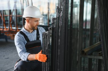 Alüminyum, PVC pencere ve kapı üretim fabrikası. PVC pencere ve kapılarını birleştiren el işçisi