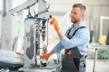 Alüminyum, PVC pencere ve kapı üretim fabrikası. PVC pencere ve kapılarını birleştiren el işçisi.