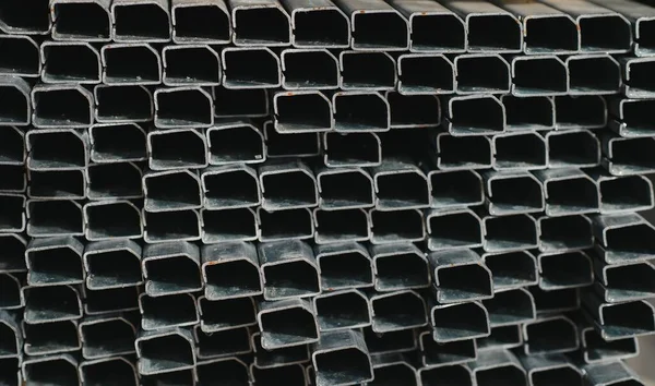 Stack of rolled metal products, perspective view of steel pipes of rectangular cross-section.