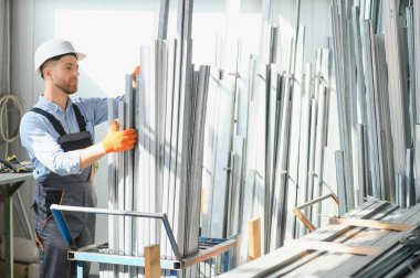 Profesyonel kumaş işçisi. Metal işleme tesisi. Metal profil deposunda çalışan bir işçi.