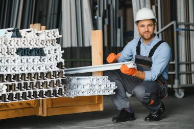 Alüminyum, PVC pencere ve kapı üretim fabrikası. PVC pencere ve kapılarını birleştiren el işçisi.