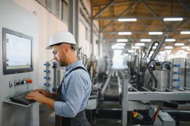 Alüminyum, PVC pencere ve kapı üretim fabrikası. PVC pencere ve kapılarını birleştiren el işçisi