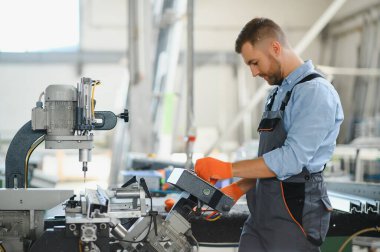 Alüminyum ve PVC profilleri kesen el işi işçisi. İmalat işleri. Seçici odaklanma. Alüminyum ve PVC pencere ve kapı üretim fabrikası