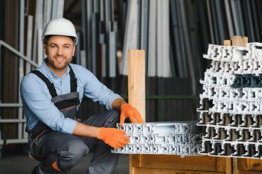 Alüminyum, PVC pencere ve kapı üretim fabrikası. PVC pencere ve kapılarını birleştiren el işçisi.