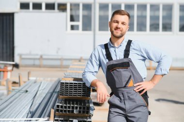Profesyonel kumaş işçisi. Metal işleme tesisi. Metal profil deposunda çalışan bir işçi.