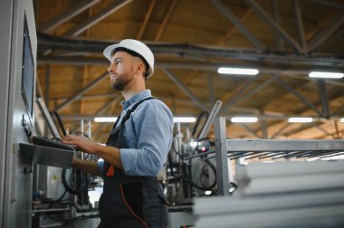 Alüminyum, PVC pencere ve kapı üretim fabrikası. PVC pencere ve kapılarını birleştiren el işçisi