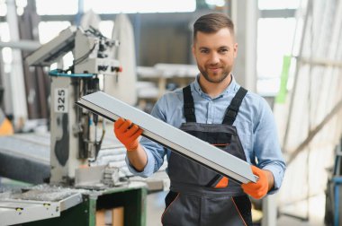 Alüminyum, PVC pencere ve kapı üretim fabrikası. PVC pencere ve kapılarını birleştiren el işçisi