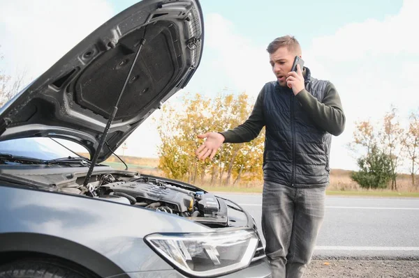 stock image Man checking his broke down car.