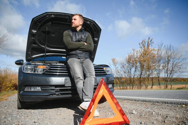 A young man with a black car that broke down on the road,copy space