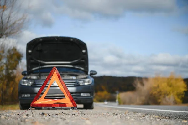 stock image breakdown triangle stands near a broken car