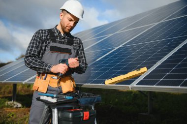 Dışarıda güneş panelleri kuran işçiler.