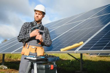 Dışarıda güneş panelleri kuran işçiler.