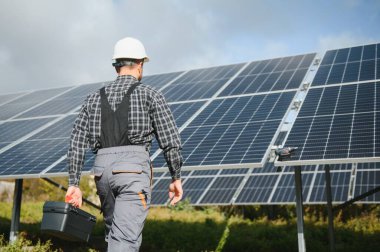 Metal yapıya güneş panelleri yerleştiren profesyonel işçiler, farklı ekipmanlar kullanıyorlar, kask takıyorlar. Enerji çözümü için yenilikçi bir çözüm. Yenilenebilir kaynakları kullan. Yeşil enerji