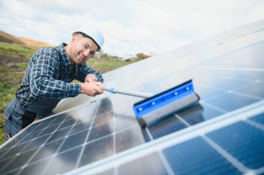 technician operating and cleaning solar panels at generating power of solar power plant technician in industry uniform on level of job description at industrial. clipart