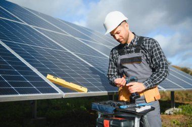 Güneşli bir günde üniformalı ve güneş pilli bir erkek işçi.