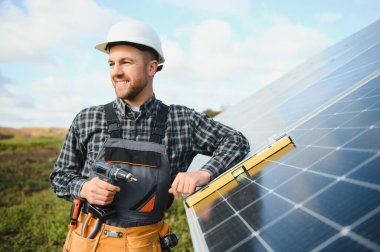 Metal yapıya güneş panelleri yerleştiren profesyonel işçiler, farklı ekipmanlar kullanıyorlar, kask takıyorlar. Enerji çözümü için yenilikçi bir çözüm. Yenilenebilir kaynakları kullan. Yeşil enerji