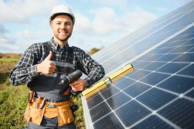 Dışarıda güneş panelleri kuran işçiler.