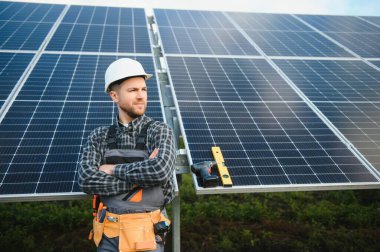 Metal yapıya güneş panelleri yerleştiren profesyonel işçiler, farklı ekipmanlar kullanıyorlar, kask takıyorlar. Enerji çözümü için yenilikçi bir çözüm. Yenilenebilir kaynakları kullan. Yeşil enerji