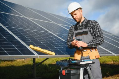 Güneş enerjisi santrali işçisi panellerin durumunu kontrol ediyor.