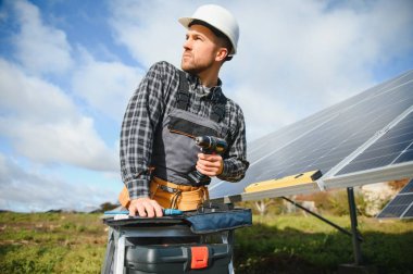 Güneşli bir günde üniformalı ve güneş pilli bir erkek işçi.